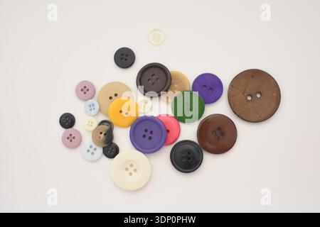 Colorful Buttons Scattered on White Table, Top View Flat Lay Stock Photo