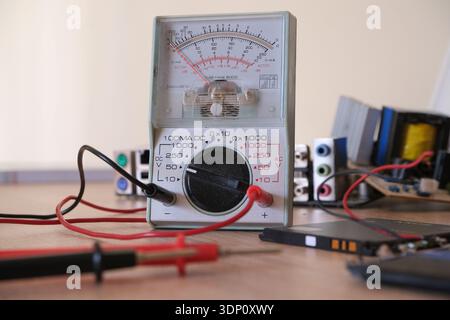 Electronics repair and restoration workbench with analog multi meter. Stock Photo