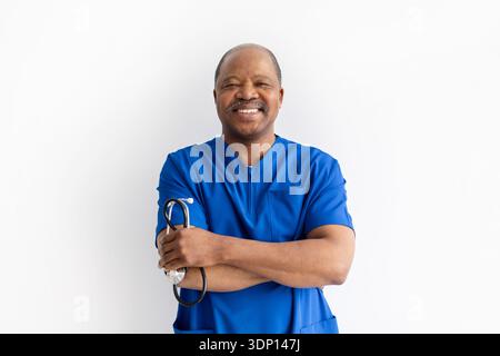 Mature black male doctor standing with arms crossed and stethoscope, smiling confidently Stock Photo
