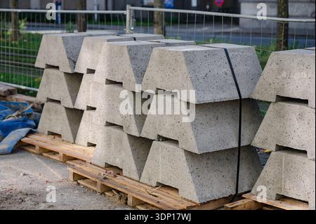 Rows of stacked gray concrete paving blocks with rough surfaces and layered textures. High quality photo Stock Photo
