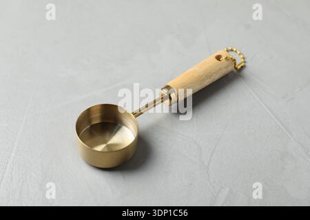 Golden scoop on gray textured table, closeup Stock Photo