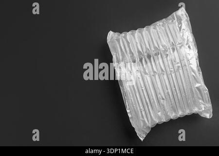 Transparent air buffer packaging on black background, top view. Space for text Stock Photo