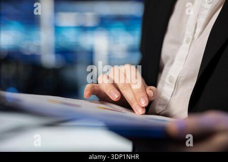 Close up of server room worker reading report files after cloud computing infrastructure rigs inspection. Data center expert doing maintenance on gear powering internet services, analyzing documents Stock Photo