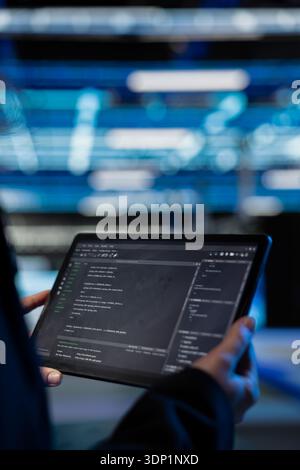 Writing code, tablet closeup and computer scientist in data center updating infrastructure network systems. Coding upgrades and worker typing on touchscreen device in server hub Stock Photo