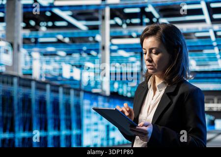 Infrastructure checkup, tablet and technician in data center, doing on computing, VFX compositing overlay. Device, server room employee, walking between blue wireframe mainframes Stock Photo