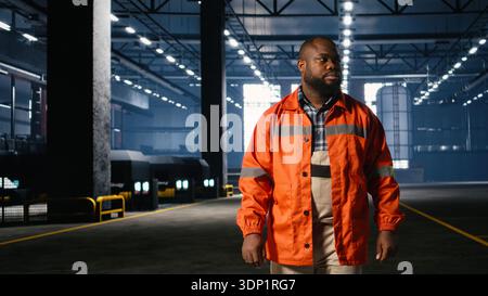 African american man overseeing equipment during assembly in warehouse, illustrating manufacturing development with industrial labor and manpower. Steel production workshop. Stock Photo