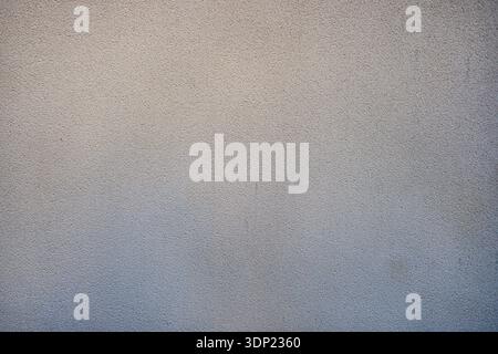 Smooth structural plaster wall texture. Light yellow, pale beige and brownish tones with subtle dark spots. Even uniform decorative stucco background. Stock Photo