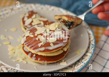 Homemade pancakes with chocolate filling and almond slices served on a plate Stock Photo