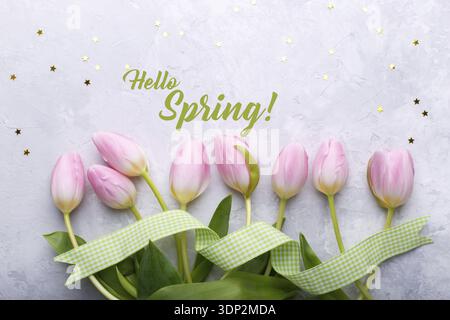 Bouquet of pink tulips in a wicker basket on light gray background, hello spring concept Stock Photo