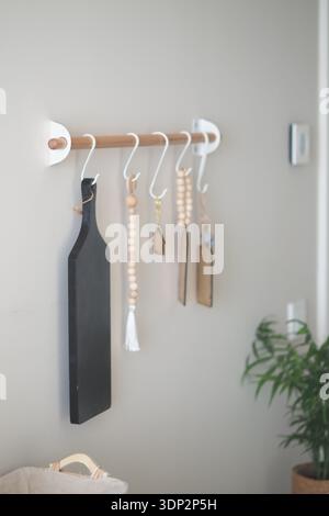 Kitchen items are arranged on a wall rack in a home Stock Photo
