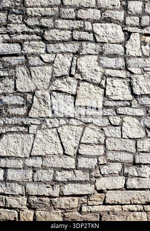 Ancient weathered rough stone wall as creative background. Grunge brick wall texture background Stock Photo
