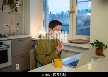 Amazed smiling senior businesswoman looking at laptop screen with surprised smiling expression. Stock Photo