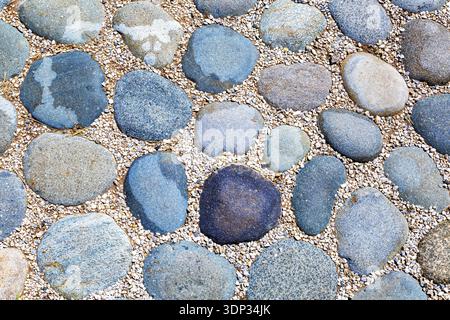Cobblestone pavement on the road as creative background texture Stock Photo