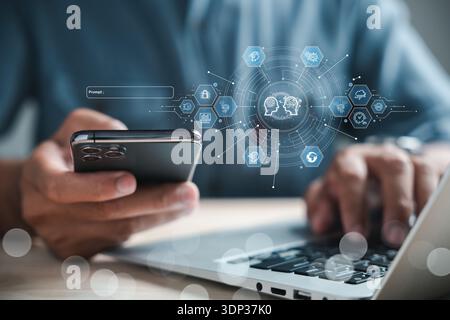 Hands type on a laptop while holding a phone, connected by a network of icons showing data flow, global communication, security, and artificial intell Stock Photo