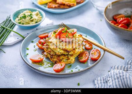 Vegetable zucchini fritters in stack with sour cream dip. Healthy vegetarian food Stock Photo