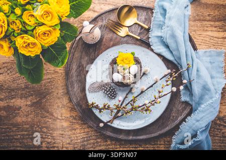 Overhead view of an Easter place setting with Easter eggs and flowers Stock Photo
