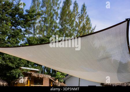 Sunshade Fabric Billowing In Afternoon Breeze, A gentle photo of fabric billowing breeze, soft cloth rippling , perfect for summer comfort or outdoor Stock Photo