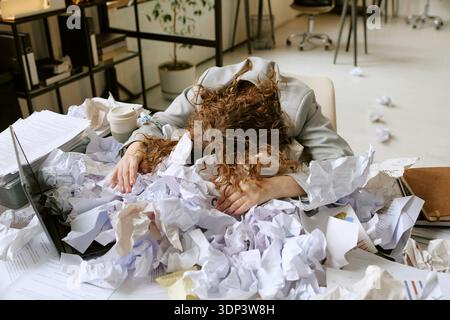 Young Woman Overwhelmed by Work Stress in Modern Office Setting Stock Photo