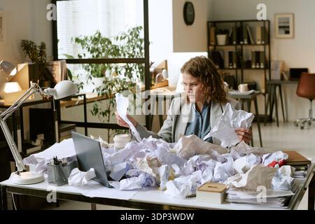 Young Woman Analyzing Documents at Desk in Modern Office Stock Photo