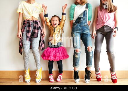 Dancing, friends and children by wall in studio with rhythm, practice or performance at rehearsal. Students, group and girl kids with training for hip Stock Photo