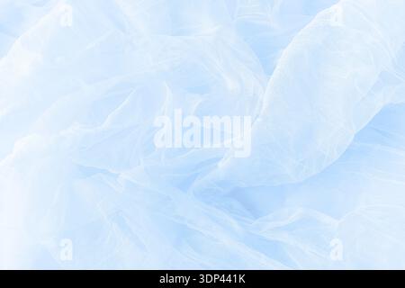 Soft drapery light blue tulle fabric texture background. Creased tulle backdrop. Stock Photo