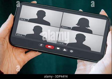 Close-up of a smartphone displaying a group video conference call interface. Ideal for remote work, online meetings, virtual teamwork, telecommunicati Stock Photo