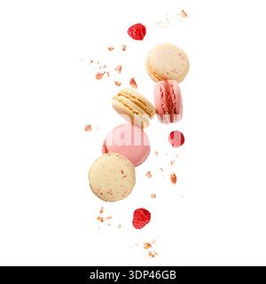 Sweet macaroons macarons with raspberry berries and crumbs flying isolated on  white background. French cookies with vanilla, raspberry and strawberry Stock Photo