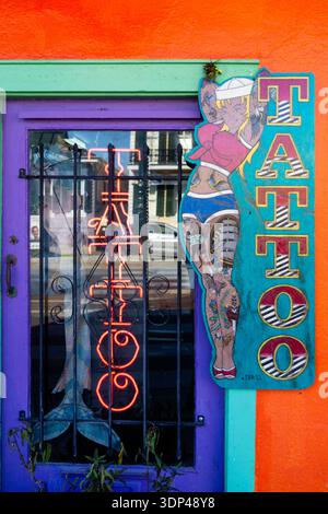 A colorful storefront of a tattoo studio featuring bold signage and vibrant colors. Stock Photo