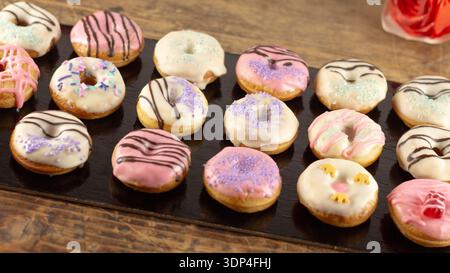 Mini donuts covered in chocolate on a black background. Stock Photo