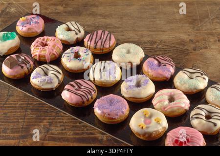 Mini donuts covered in chocolate on a black background. Stock Photo