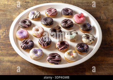 Mini donuts covered in chocolate on a white background. Stock Photo