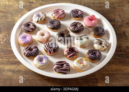 Mini donuts covered in chocolate on a white background. Stock Photo