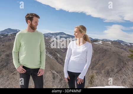 Active couple smiling together on a winter mountain summit Stock Photo
