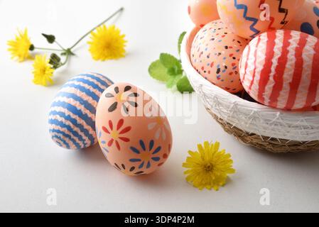 Colorful Easter Eggs in Basket with Flowers Stock Photo