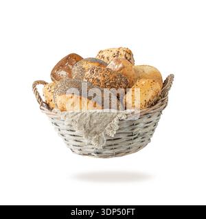 Fresh various crispy bread buns in rustic wicker basket flying falling isolated on white background. Poppy, sesame, flax and sunflower seeds whole bun Stock Photo