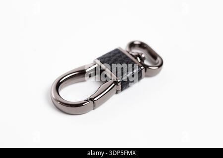 Stylish black leather and stainless steel keychain carabiner isolated on white. Stock Photo