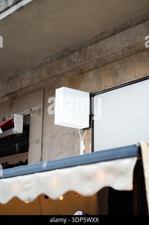 Blank white lightbox signage mockup hanging on an old urban stone wall Stock Photo