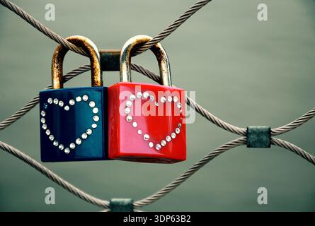 Two grungy love padlocks with heart decoration attached to the bridge in Paris. Valentine's day background. Toned photo. Stock Photo