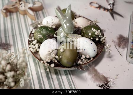 Rustic Easter still life with olive eggs and decor. Stock Photo