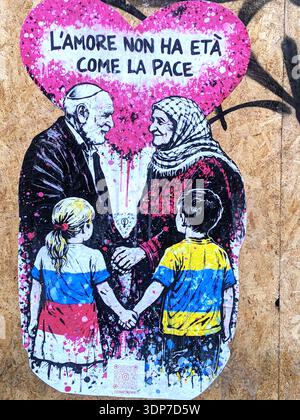 Milan, love is as ageless as peace. A work by CDonati Meyer for a peaceful Valentine's Day. For Valentine's Day, a street art project that combines visual language and civic engagement in a universal message. Created in graffiti style with a palette of fuchsia, black, and white, the work depicts an elderly couple-an Israeli man and a Palestinian woman-holding hands beneath a large heart covered in drippings and splashes of color. In front of them, two children-a girl in the colors of Russia and a boy in those of Ukraine-also hold hands. Stock Photo