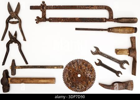Flat lay of old hand tools on white background. Large collection of various rusty tools and bits arranged on white. Stock Photo