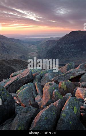Rocky summit foreground overlooking the sunset over Ogwen Valley from the Glyderau mountains, Snowdonia National Park, Gwynedd, North Wales, UK. Stock Photo