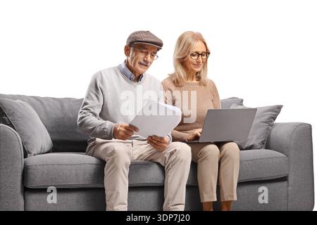 Mature man reading a document and woman using a laptop computer isolated on white background Stock Photo