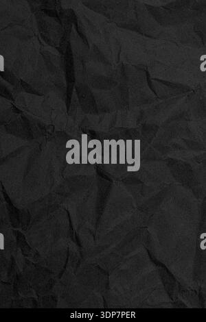 Dark wrinkled paper creating an abstract and distressed charcoal material surface Stock Photo