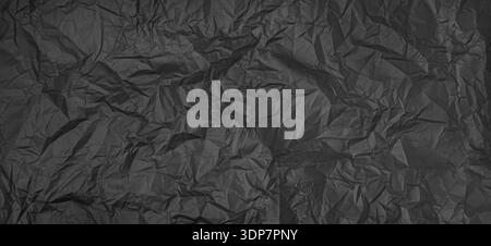 Crumpled black paper surface showing texture and abstract patterns Stock Photo