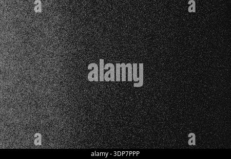 Abstract dark grainy background showing a black and gray noise texture surface Stock Photo