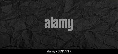 Black crumpled paper background showing intricate wrinkles and a rough textured surface Stock Photo