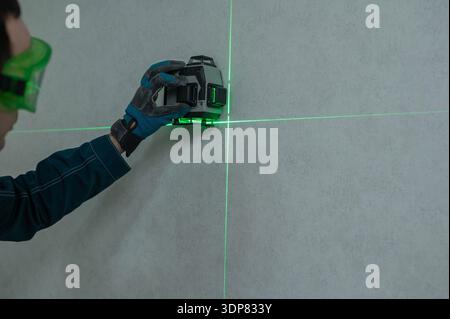 A man measures distance with a laser level.  Stock Photo