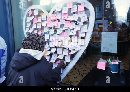 Dublin, Ireland - 13th February 2026: A woman writes a festive note for a sticky message heart shaped window display at the Mercantile Hotel on Dame Street in Dublin city during the build up to Saint Valentine's Day in the Irish capital as Irish people prepare to celebrate the annual day dedicated to love and romance Stock Photo