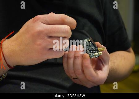Technician repairing a microcircuit with a soldering iron. Stock Photo